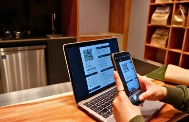 a person using a laptop and a cell phone